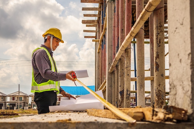 Ingenieur, der den Betonboden auf der Baustelle des Hauses misst