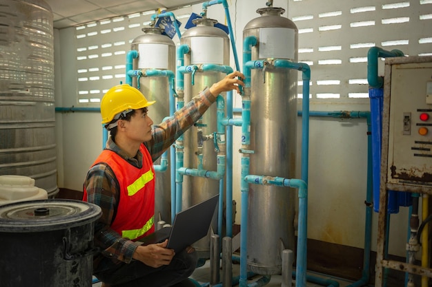 Ingenieur, der in einer Trinkwasserfabrik arbeitet, überprüft das Wassermanagementsystem und die Kesselwasserleitung