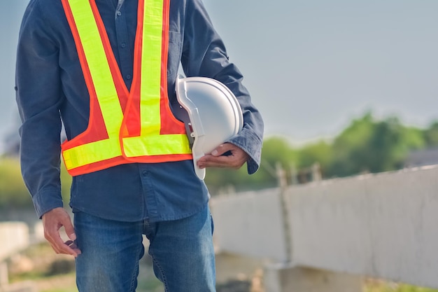 Ingenieur, der Schutzhelmbauarbeiterberufssicherheitsarbeitsindustriegebäude-Personenmanagerservice hält