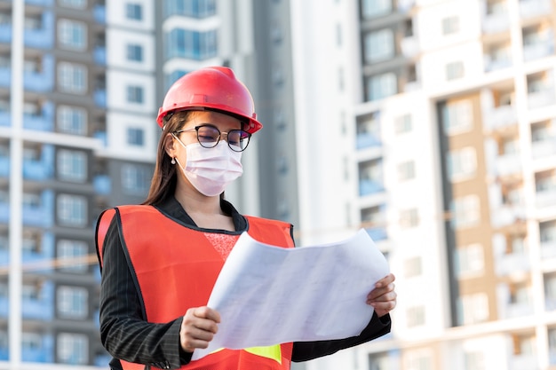 Ingenieur, der steht, um Baupläne auf der Baustelle zu inspizieren