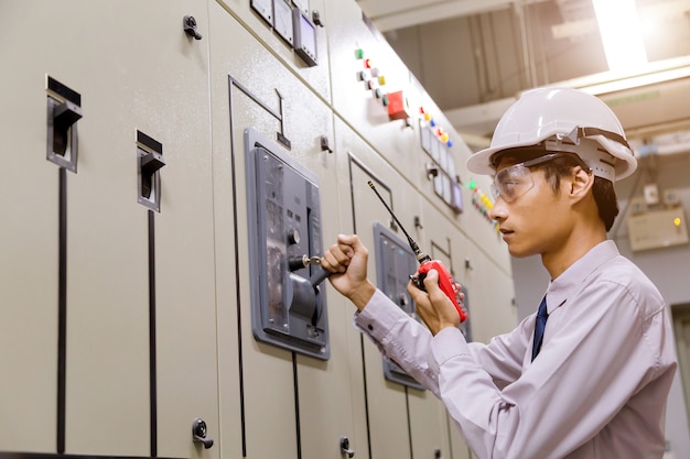 Ingenieur, der vor dem Bedienfeld im Kontrollraum steht.