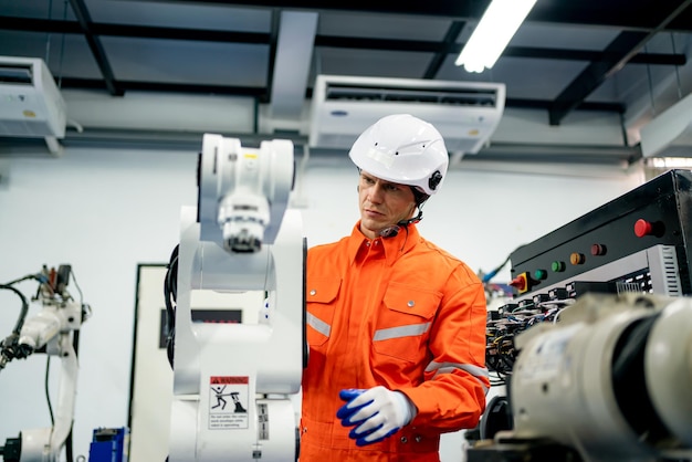 Ingenieur Mann, der an Industrierobotern in der Fabrikindustrierobotik und im digitalen Fertigungsbetrieb arbeitet