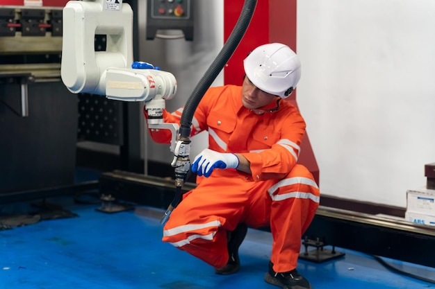 Ingenieur Mann, der an Industrierobotern in der Fabrikindustrierobotik und im digitalen Fertigungsbetrieb arbeitet