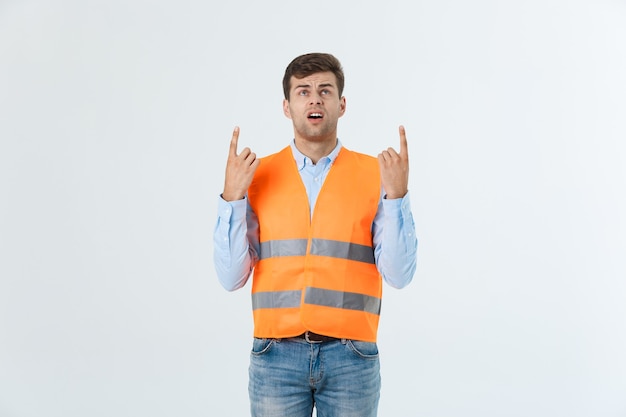 Ingenieur Mann im orangefarbenen Helm zeigt mit dem Finger, um den Raum zu kopieren.