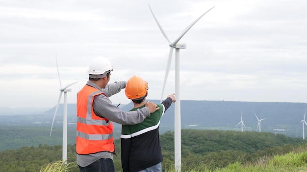 Ingenieur mit seinem Sohn auf einem Windpark auf einem Hügel oder Berg im ländlichen Raum. Fortschrittlich, ideal für die zukünftige Produktion erneuerbarer, nachhaltiger Energie. Energieerzeugung aus Windkraftanlagen