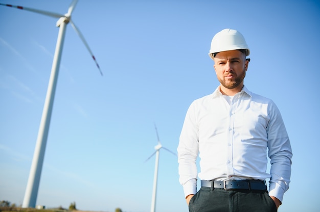 Ingenieur überprüft die Energieproduktion einer Windkraftanlage. Arbeiter im Windmühlenpark im Helm.