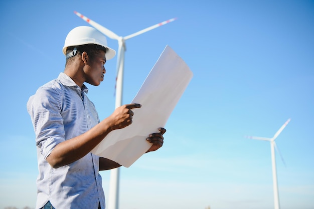 Ingenieur überprüft Windkraftanlage mit einem Tablet. Alternative Energie. Windpark. Saubere erneuerbare Energietechnologien. Windkraftanlagen