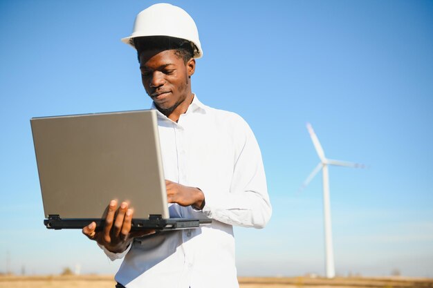 Ingenieur überprüft Windturbinensystem mit einem Tablet. Alternative Energie. Windpark. Saubere erneuerbare Energietechnologien. Windkraftanlagen