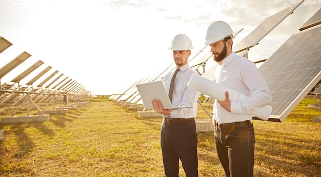 Ingenieure, die im Feld mit Sonnenkollektoren arbeiten