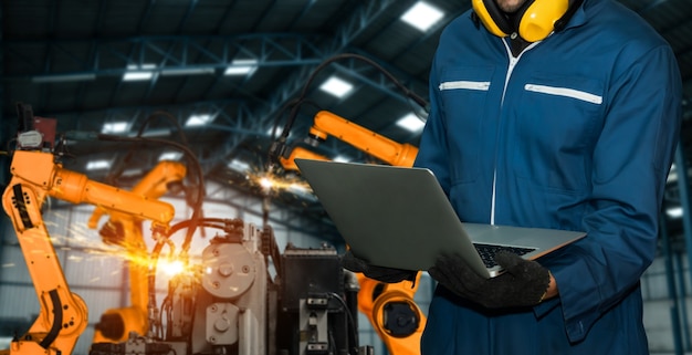 Ingenieure verwenden fortschrittliche Robotersoftware, um den Roboterarm der Industrie in der Fabrik zu steuern