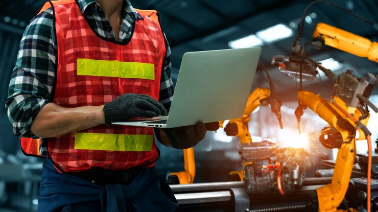 Foto ingenieure verwenden fortschrittliche robotersoftware, um den roboterarm der industrie in der fabrik zu steuern