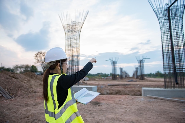 Ingenieurfrau, die am Standort der im Bau befindlichen Brücke arbeitet