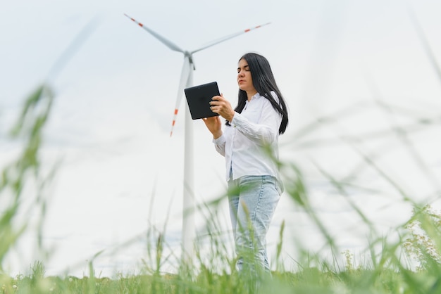 Ingenieurin, die mit Tablet im Windkraftpark arbeitet