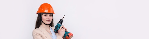 Ingenieurin in einem orangefarbenen Bauhelm mit einem Schraubendreher und einem Hammer auf weißem Hintergrund