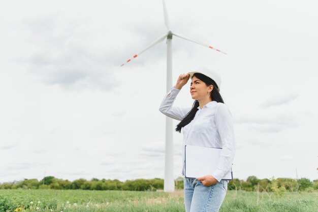 Ingenieurin mit Schutzhelm bei der Arbeit im Windkraftpark