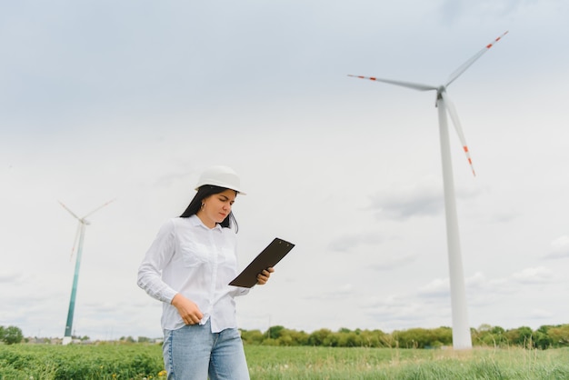 Ingenieurin mit Schutzhelm im Windkraftpark