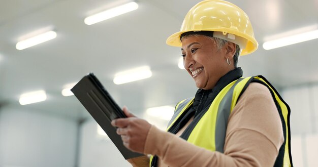 Foto ingenieurin und tablet auf der baustelle inspektion gebäudeentwicklung und industrielle renovierung aufgeregter manager für digitale tech-design-software und architekturplanung im lagerhaus