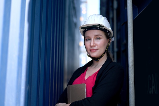 Foto ingenieurinnen stehen selbstbewusst da, container laden hintergrund. frauen sind selbstbewusst oder ingenieurinnen sind selbstbewusst