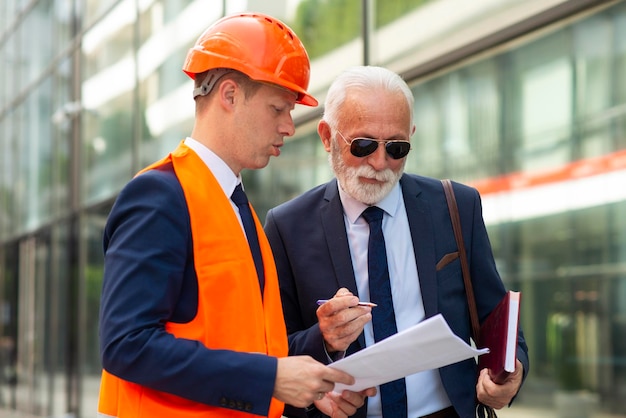 Foto ingenieurmann, der mit leitendem geschäftsmann spricht