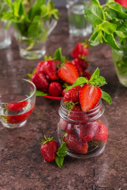 Ingrediente para mermelada de fresa casera o mermelada en frasco de vidrio con bayas dulces maduras y hojas de menta