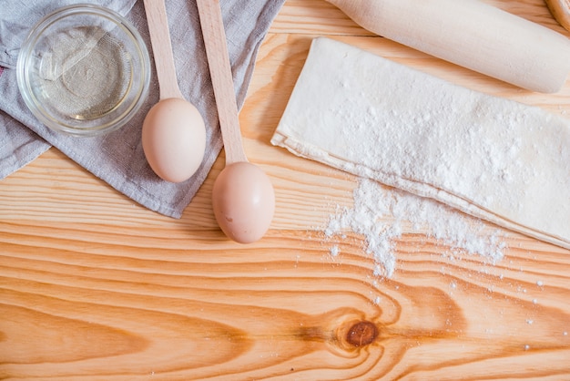 Foto ingredientes básicos para hornear, huevo y harina en mesa.