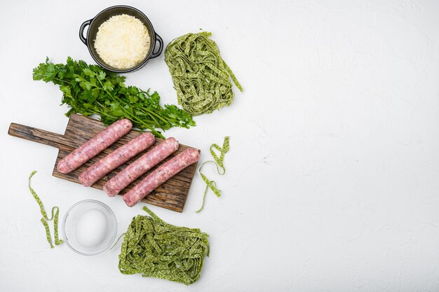 Ingredientes de carbonara de salchicha de pasta, sobre fondo de mesa de piedra blanca, vista superior plana, con espacio para copiar texto