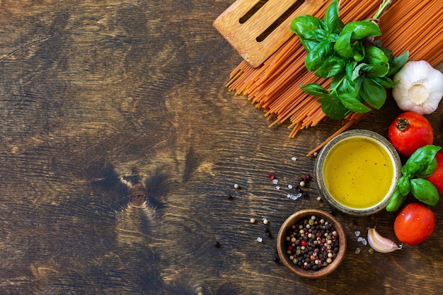 Ingredientes para la cocina italiana Tomate espaguetis hierbas especias aceite de oliva y verduras Vista superior