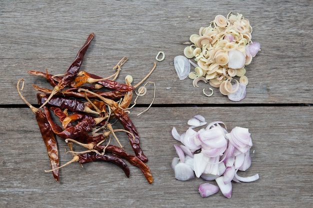 Ingredientes para la cocina tailandesa en el plato (pimientos, cebollas, limoncillo) sobre fondo de madera