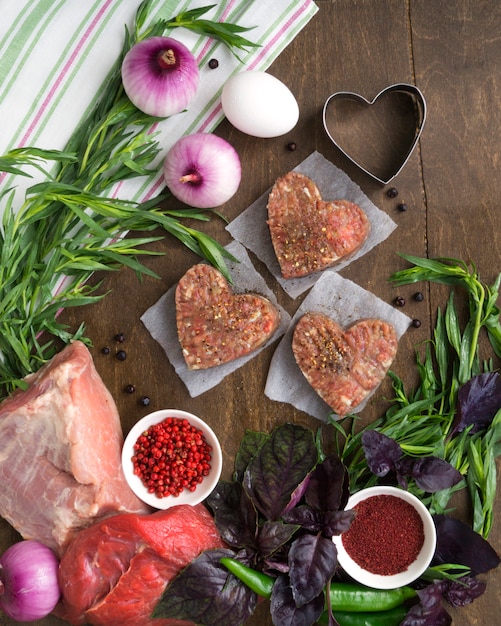 Ingredientes para cocinar chuletas en una mesa de madera. La vista desde la cima.