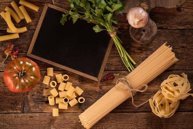 Ingredientes para cocinar comida italiana. Pastas, verduras. Vista superior con espacio de copia.