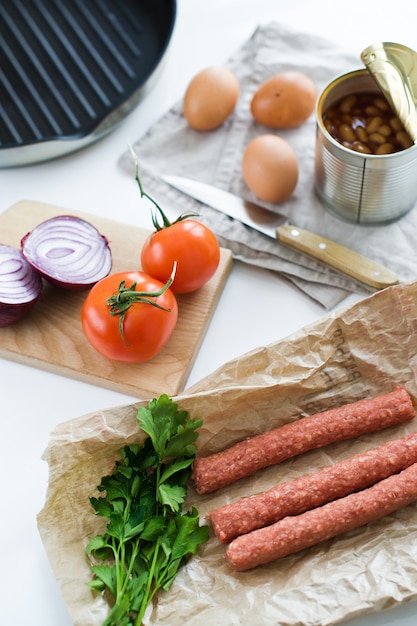 Ingredientes para cocinar un desayuno inglés en un fondo blanco.