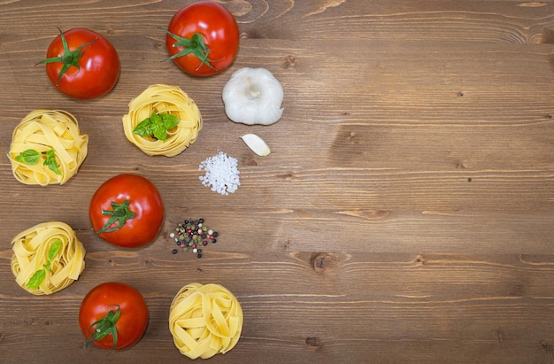 Ingredientes para cocinar la pasta italiana tradicional sobre el fondo de madera