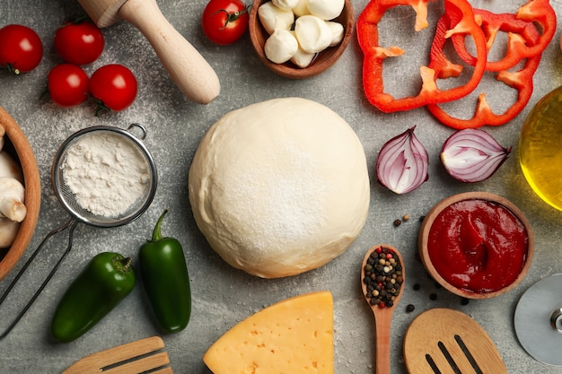 Foto ingredientes para cocinar pizza sobre fondo gris, vista superior