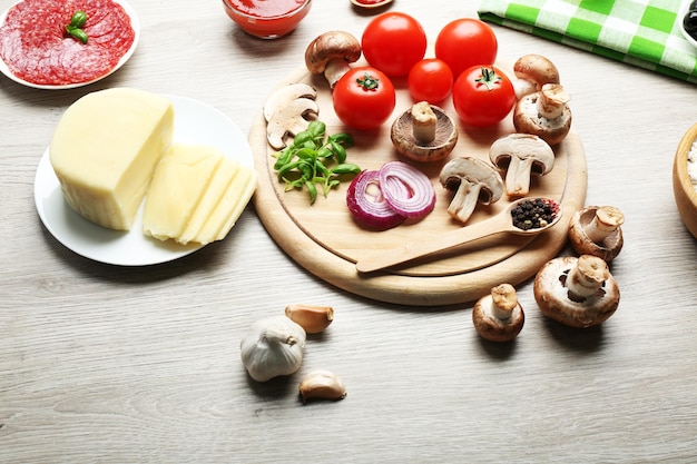 Ingredientes para cocinar pizza sobre fondo de mesa de madera