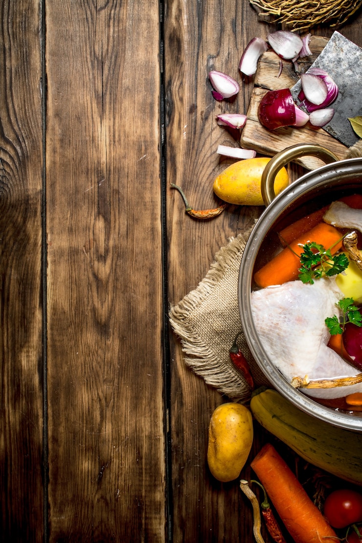 Foto ingredientes para cocinar sopa de pollo con verduras y especias. sobre una mesa de madera.