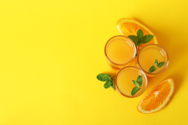 Ingredientes y cócteles de tequila sunrise sobre fondo amarillo