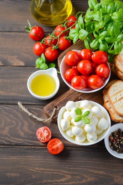 Ingredientes de comida italiana en la mesa de madera oscura.