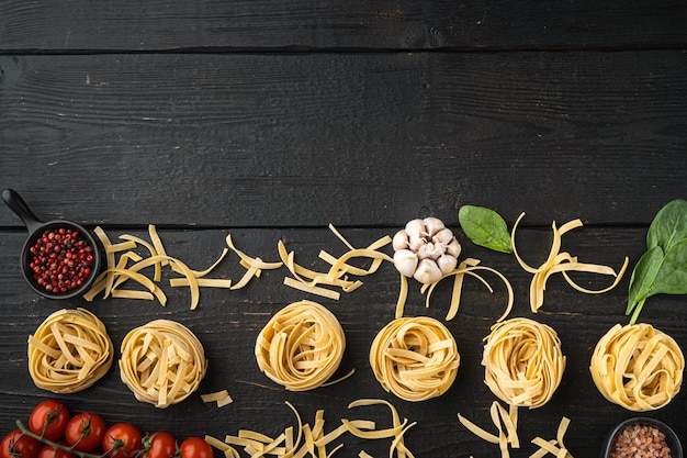 Ingredientes da massa Tagliatelle com ingredientes alimentares italianos no fundo da mesa de madeira preta vista superior plana com espaço de cópia para texto