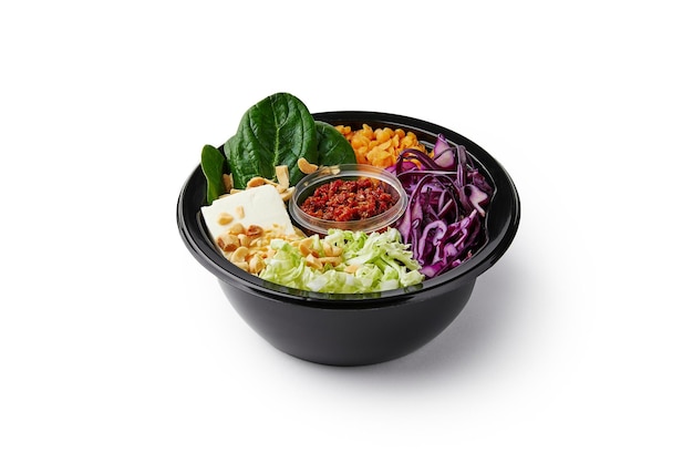 Ingredientes da salada fresca e molho vermelho em recipiente isolado no fundo branco Prato vegano