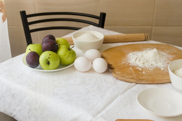 Ingredientes de cozimento Placa de ovos de maçã farinha rolo e cascas de ovos na mesa da cozinha