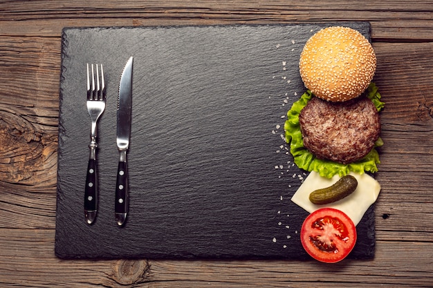 Foto ingredientes de hambúrguer de vista superior em uma placa de ardósia