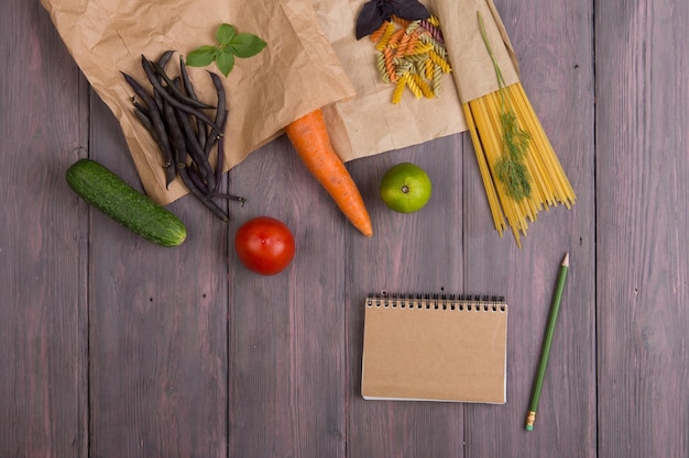 Ingredientes de massa fresca em sacos de papel eco macarrão espaguete cenoura manjericão tomate e outros vegetais