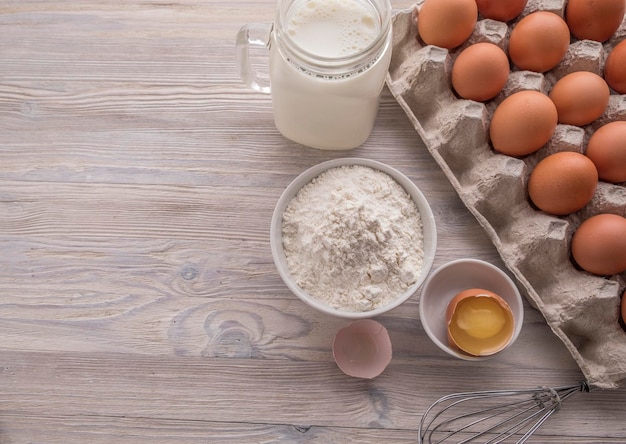 Ingredientes de padaria farinha ovos gema de leite em uma mesa vista superior espaço para texto