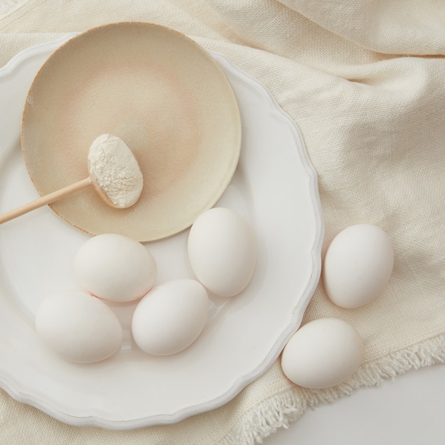 Ingredientes de panificação. Vista de cima de ovos e colher de farinha em um pano branco