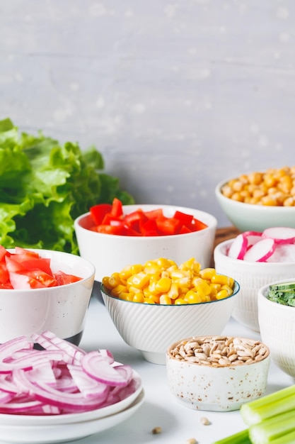 Ingredientes de sortimento para salada vegetariana saudável em diferentes porções em uma mesa O conceito de fitness e comida vegana