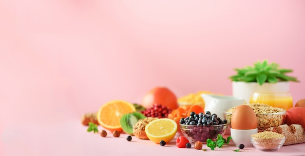 Ingredientes del desayuno saludable, marco de alimentos. Copos de avena y maíz, huevos, nueces, frutas, bayas, tostadas, leche, yogur, naranja, plátano, melocotón