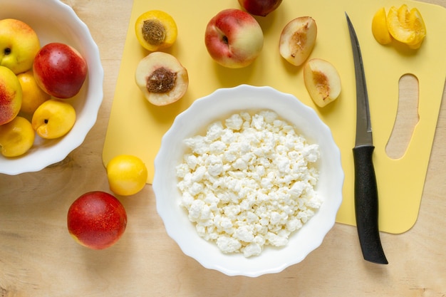 Ingredientes para un desayuno saludable. Requesón y nectarinas sobre fondo de madera, vista superior