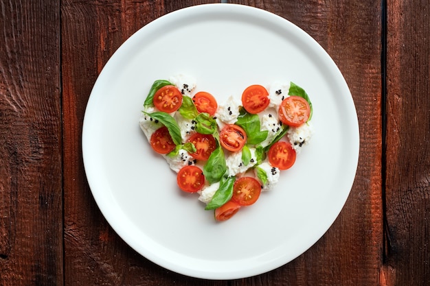 Foto ingredientes para ensalada caprese en forma de corazón. símbolo de amor por la comida italiana