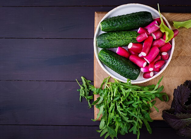 Ingredientes para ensalada fresca de pepinos, rábanos y hierbas.