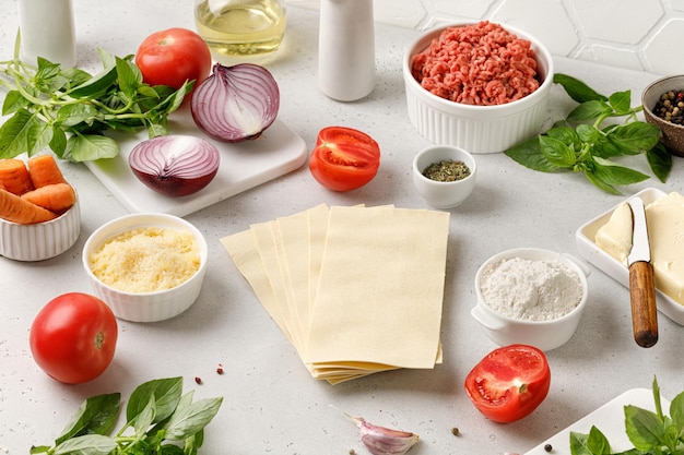 Foto ingredientes frescos para lasaña hojas de pasta queso picado tomates conjunto de varios productos para lasaña